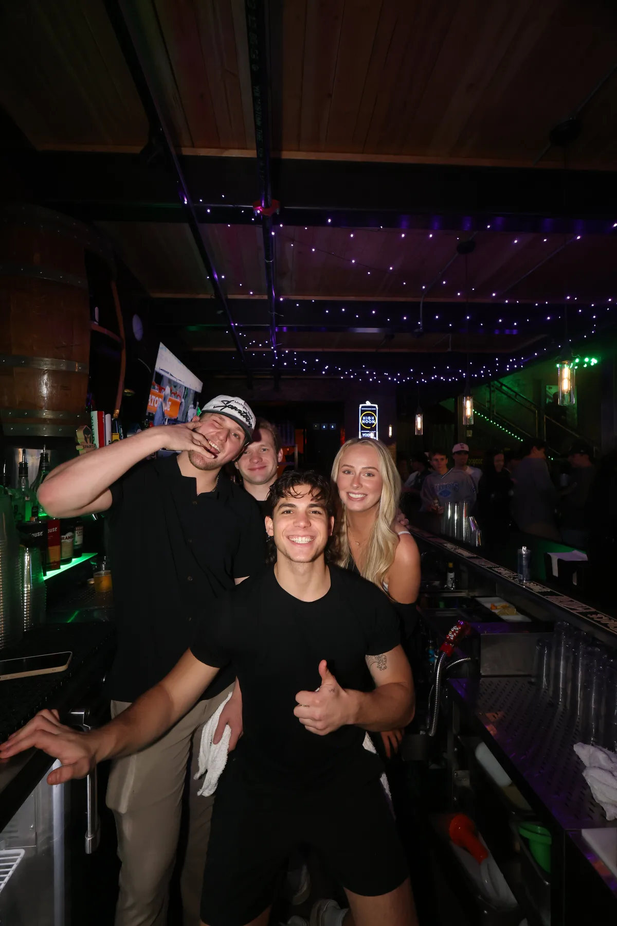 Bartenders posing together behind the bar