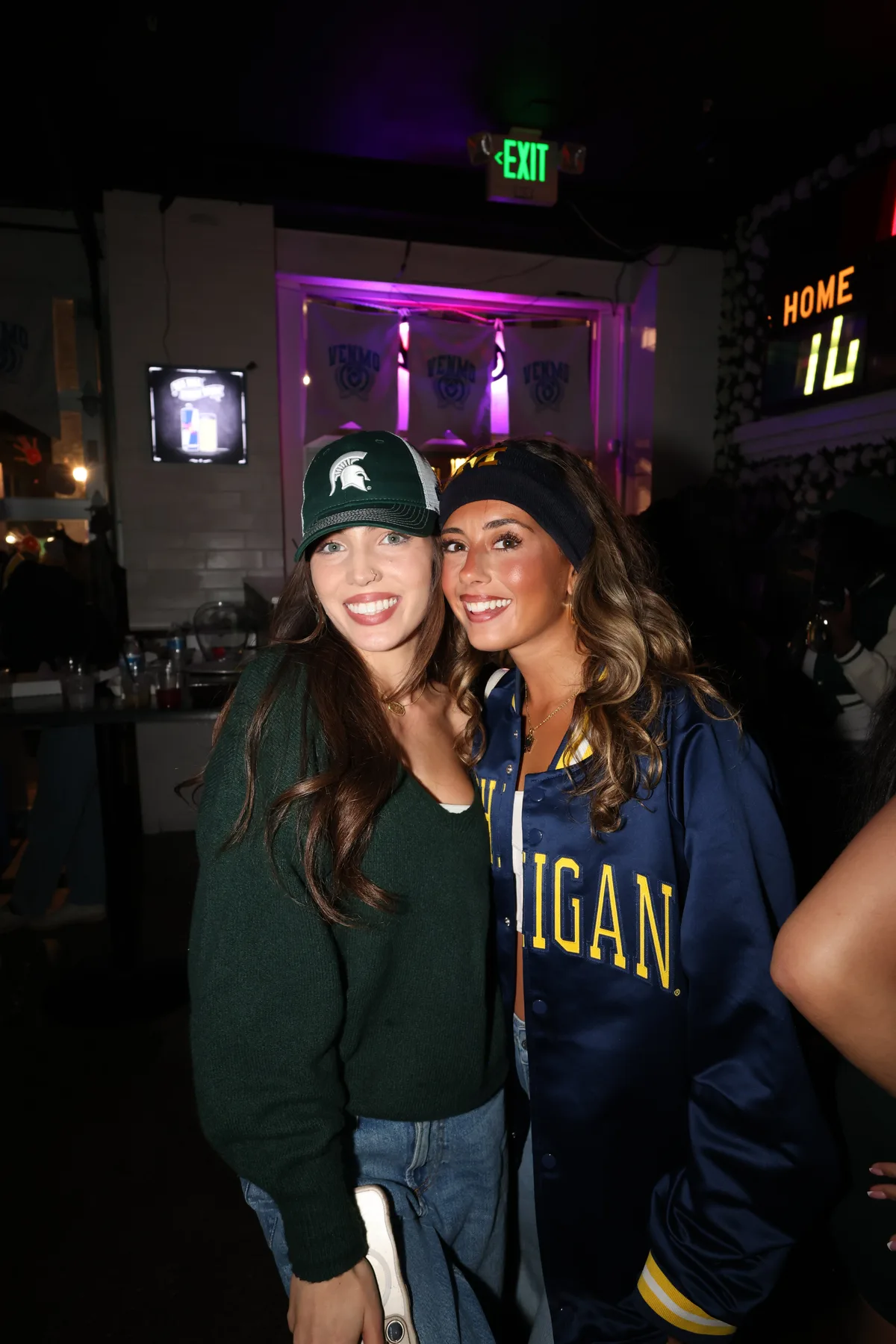 Friends posing together near a neon sign
