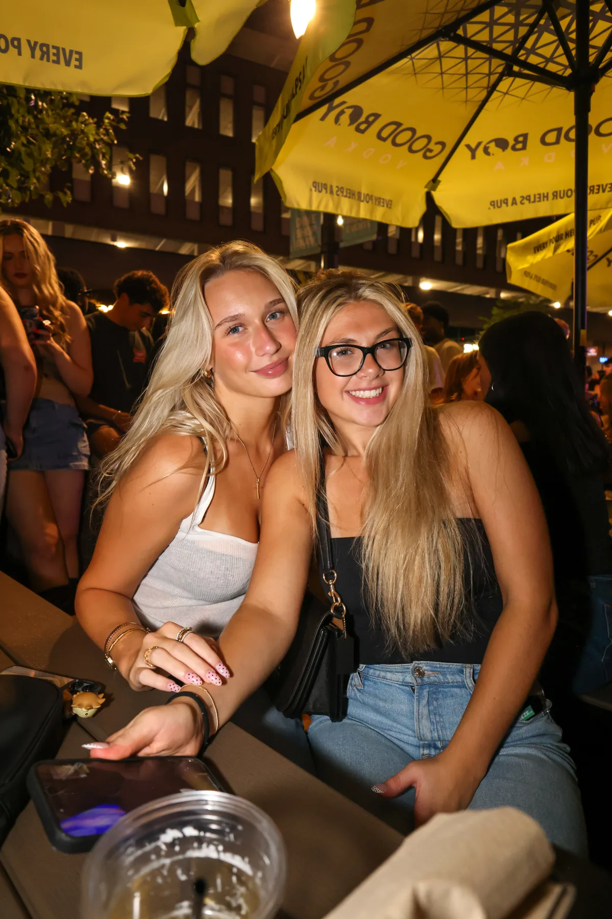 Friends posing on an outdoor patio under string lights