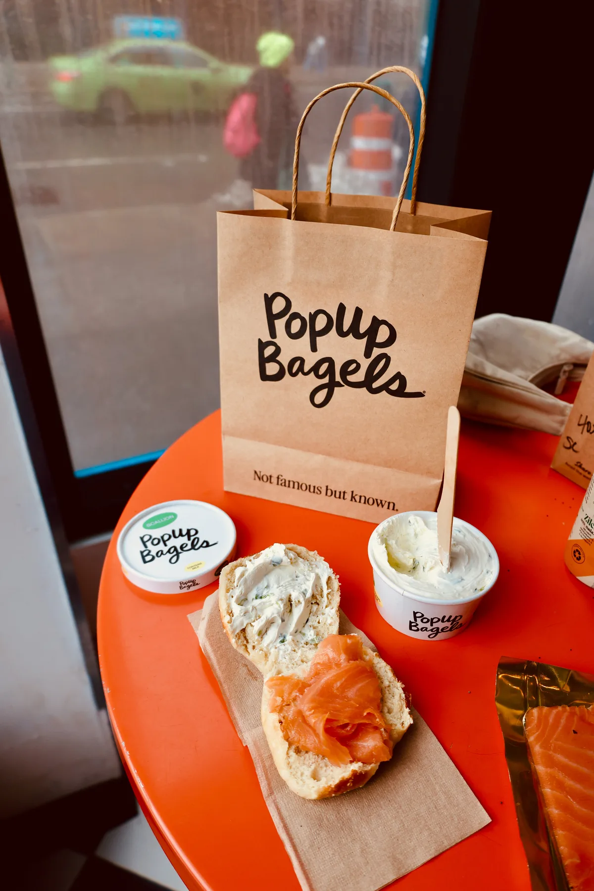 Bagel sandwich with smoked salmon and scallion cream cheese, styled on a cafe table